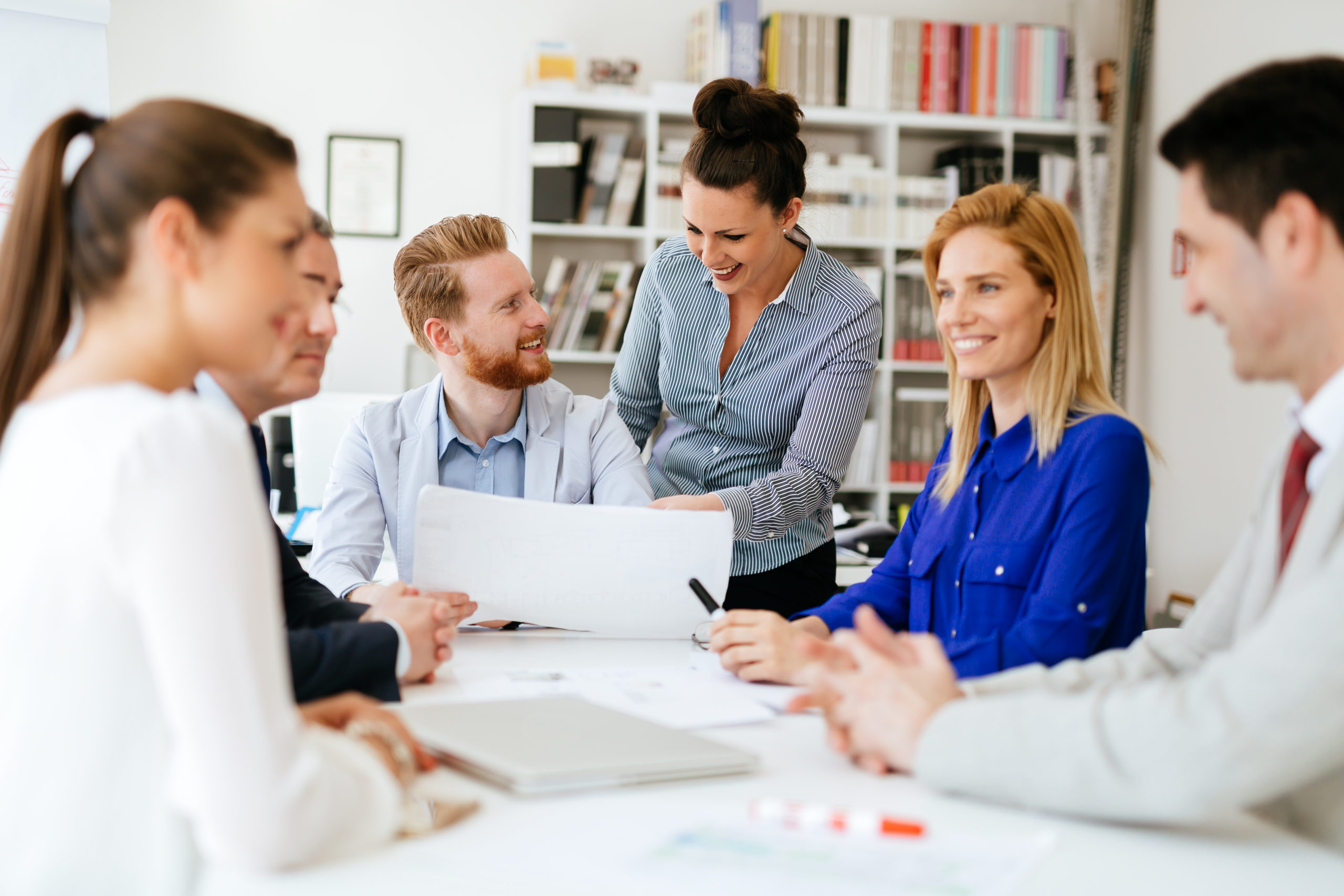 Young business people brainstorming in office discussing healthcare technology and staffing solutions.