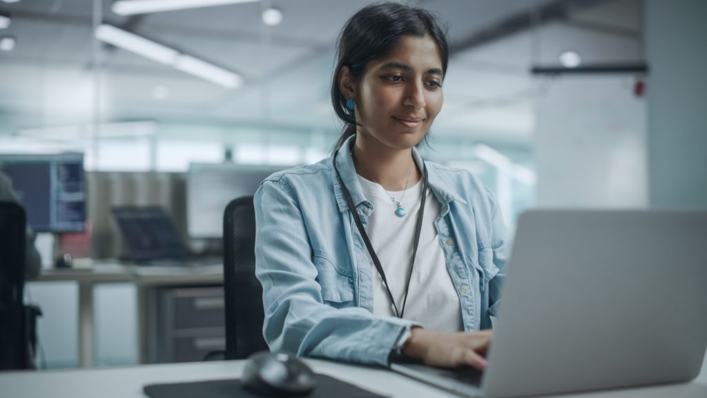 Young woman working on a laptop providing expert technology consulting services.